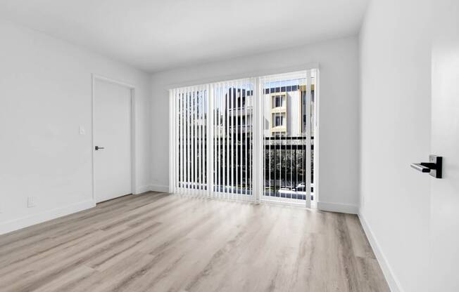 a living room with a large window and a door to a balcony