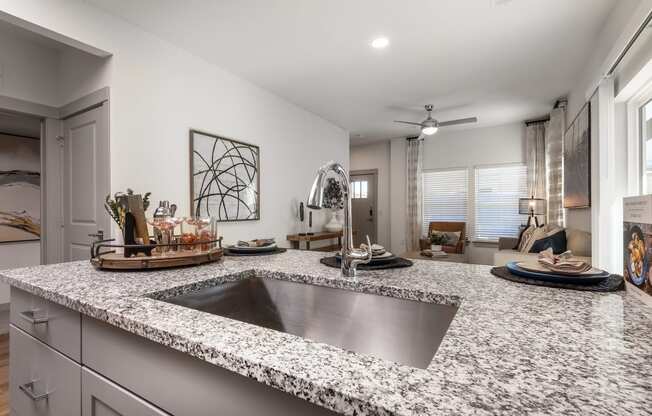 an open kitchen with granite counter tops and a sink