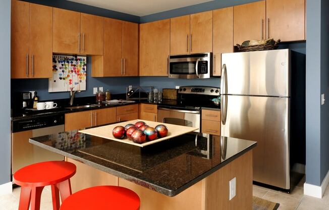 a modern kitchen with stainless steel appliances and a counter with apples