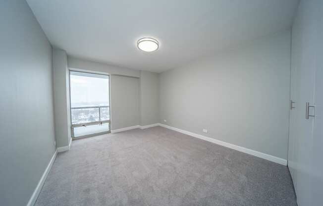 an empty living room with a window and carpet