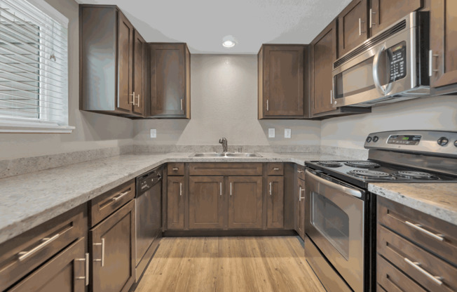 a kitchen with wooden cabinets and stainless steel appliances