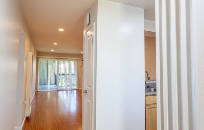 a living room and dining room with white walls and wood floors