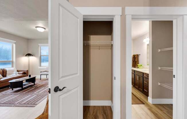A white door is open to a room with a kitchen and a living room.
