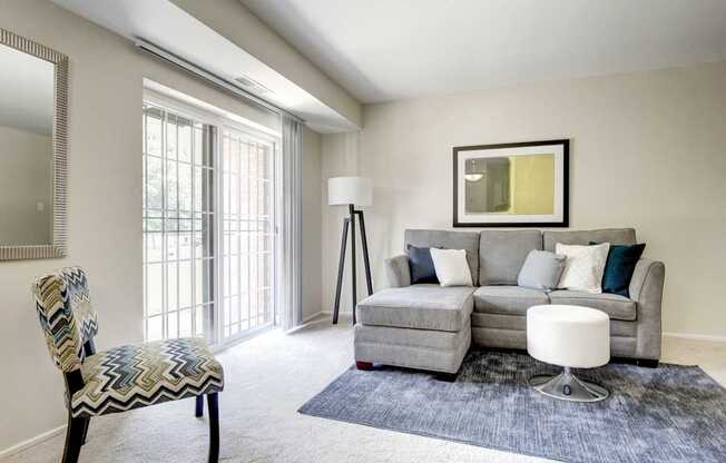 A living room with a grey couch, a chair, and a floor lamp.