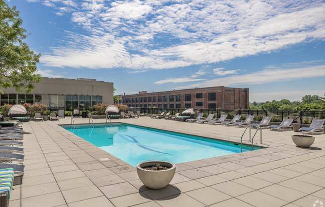 a swimming pool at a hotel with chairs around it