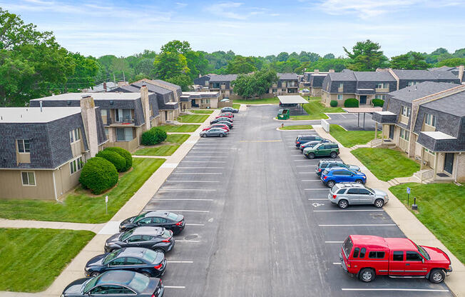 an aerial view of a parking lot with cars and houses