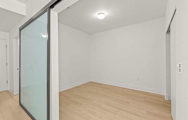 A room with a glass door and wooden flooring.