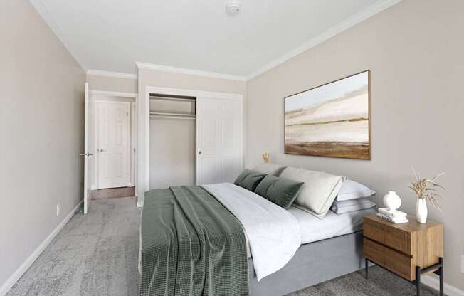 A bedroom with a bed, nightstand, and a painting on the wall.