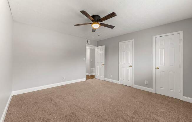 an empty living room with a ceiling fan