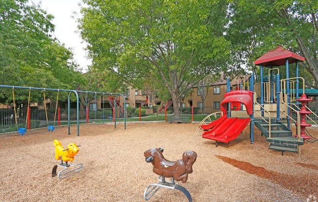 CCV playground with a red slide and a brown rocking horse.