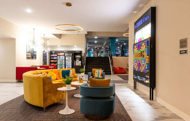 the lobby of a hotel with couches and chairs and a vending machine