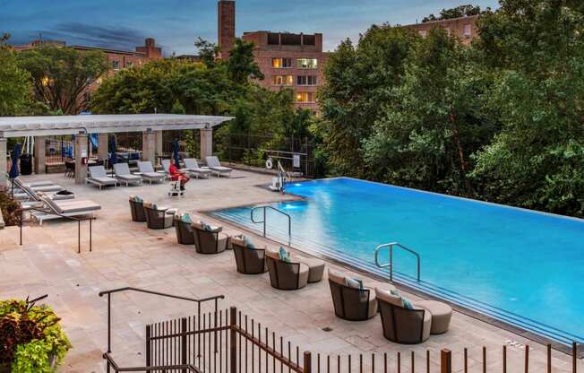 a swimming pool at a hotel with a blue pool and chairs