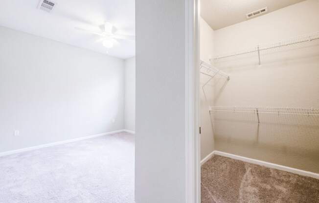 an empty bedroom with a mirrored closet and a ceiling fan  at Linden on the GreeneWay, Orlando, 32824