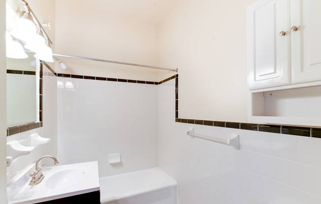 bathroom with sink, mirror, cabinet, tub and tile details at norwood apartments in washington dc