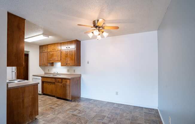 an empty kitchen and living room with a ceiling fan. Fargo, ND Betty Ann Apartments