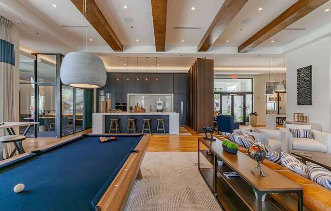 A pool table is in the middle of a room with a couch and a coffee table.