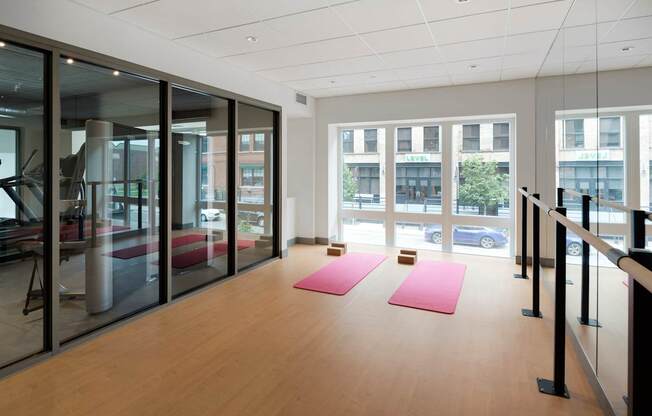 A yoga studio with pink mats and glass walls.