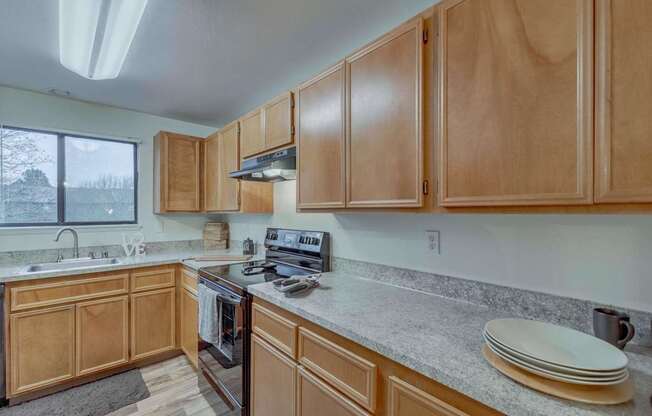 A kitchen with wooden cabinets and a stove top oven.
