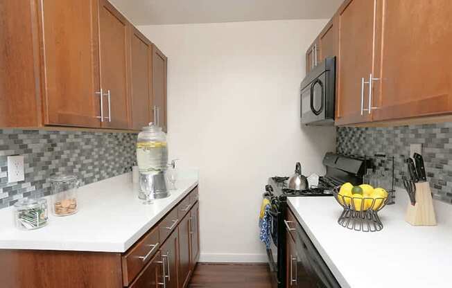 A kitchen with wooden cabinets and a white counter top.