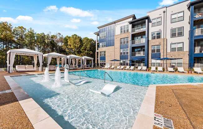 A pool with a fountain and cabanas at Preston Ridge.