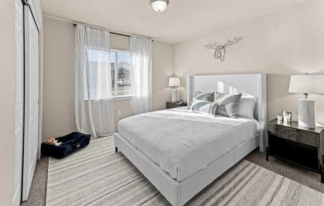 a bedroom with a white bed and white curtains