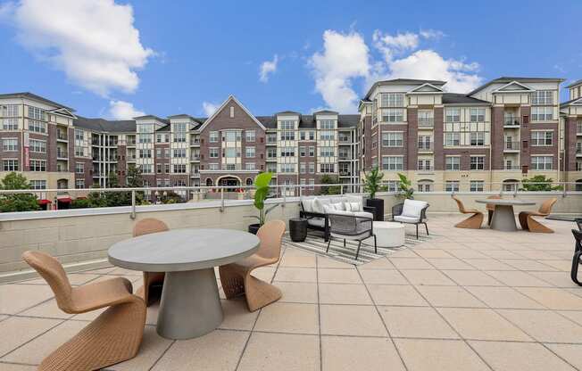 A patio with a table and chairs in front of apartment buildings.
