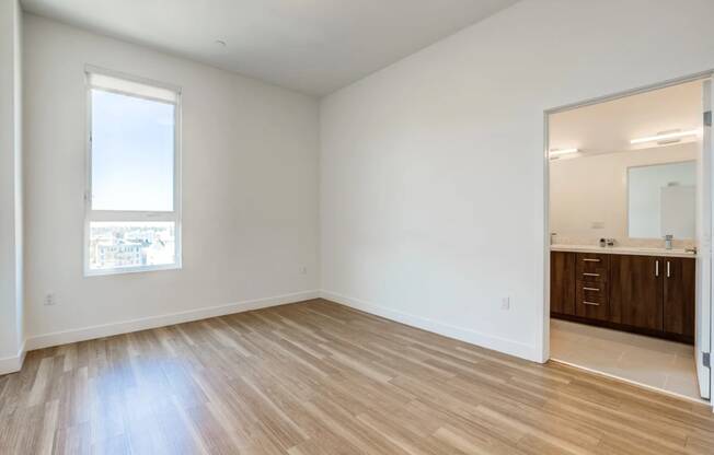 an empty living room with wood flooring and a window