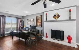 Leasing office with a white brick fireplace and a desk with chairs at Heritage Square Apartments in Waco, TX