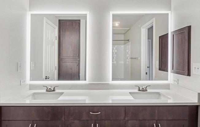 Upgraded bathrooms feature quartz countertops and backlit mirrors.