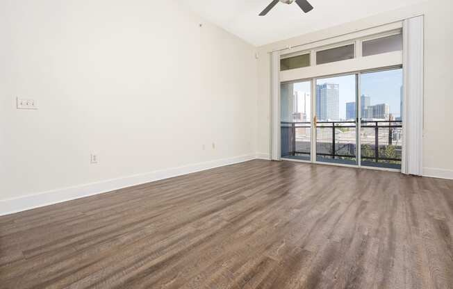 a bedroom with a large window and hardwood floors