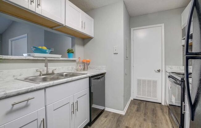 a kitchen with white cabinets and a sink and a refrigerator