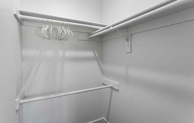 Empty white shelves with hangers.