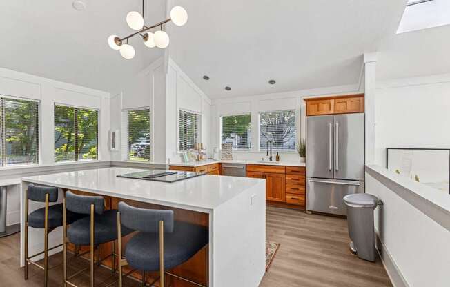 A kitchen with a white countertop and grey chairs.