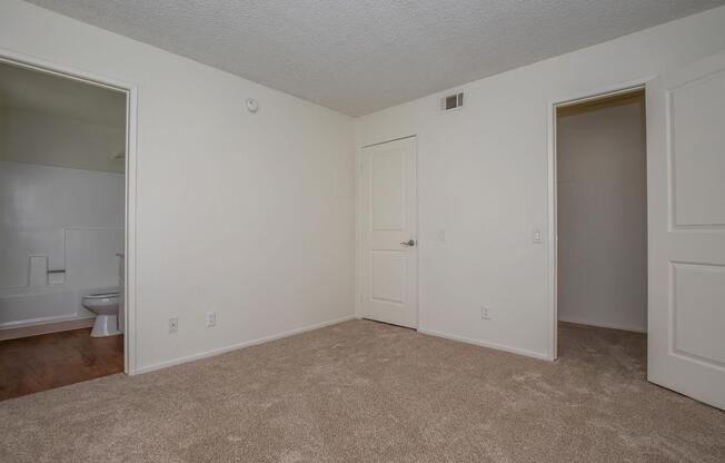 carpeted bedroom with attached bathroom and closet