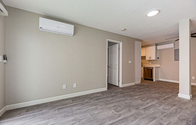 an empty living room with a door to a kitchen at Citra Apartments LLC, California