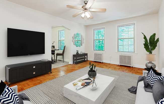 living area with sofa, coffee table, credenza, hardwood floors, large windows and view of dining area.