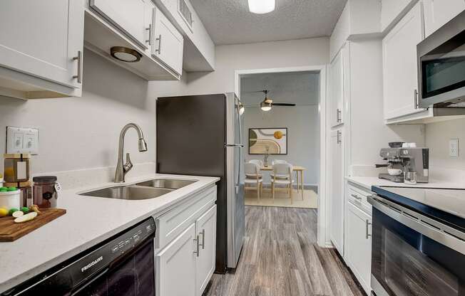 a kitchen with white cabinets and stainless steel appliances