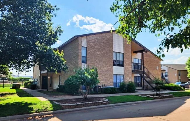 A modern brick building with a tree in front.
