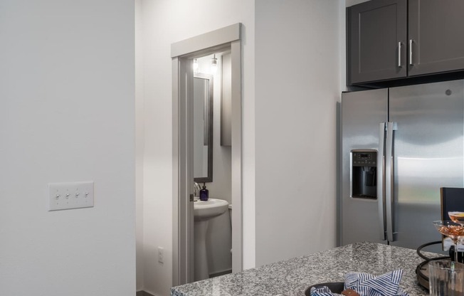 a kitchen with a granite counter top and a stainless steel refrigerator