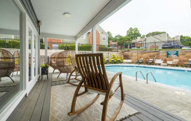 a pool and deck with rocking chairs and a pool