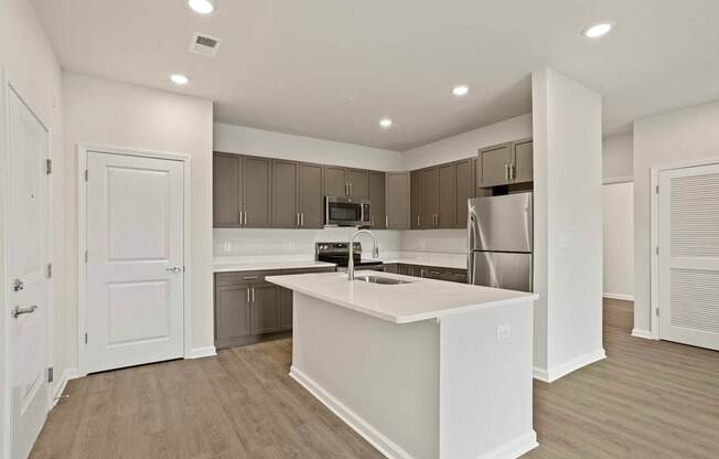 Grande at Geyser Falls Luxury Apartments Open Concept Kitchen with Quartz Countertops, Island and Stainless Steel Appliances