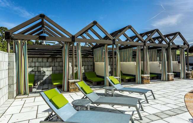 A row of sun loungers are arranged in front of a wooden structure.