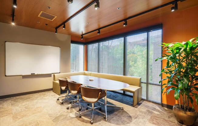 A conference room with a whiteboard and a long table with chairs.