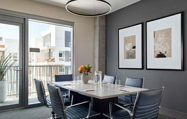 A conference room with a table, chairs, and pictures on the wall.