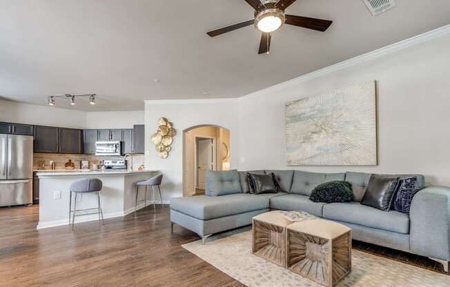 A living room with a grey couch and a wooden coffee table.