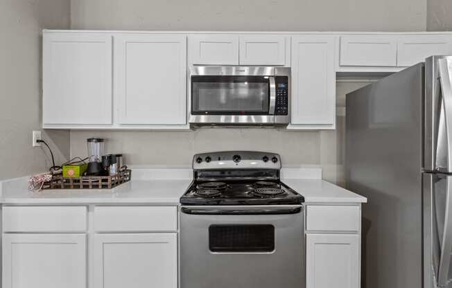 a kitchen with white cabinets and stainless steel appliances