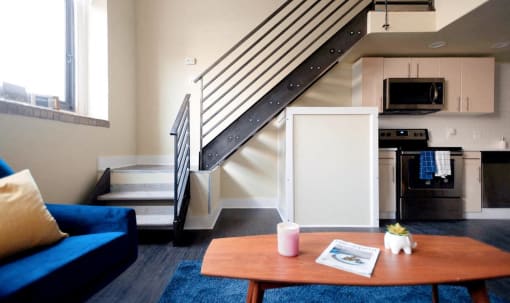 a living room with a couch a table and a staircase