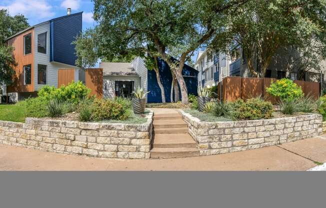 a retaining wall with stairs in front of a house