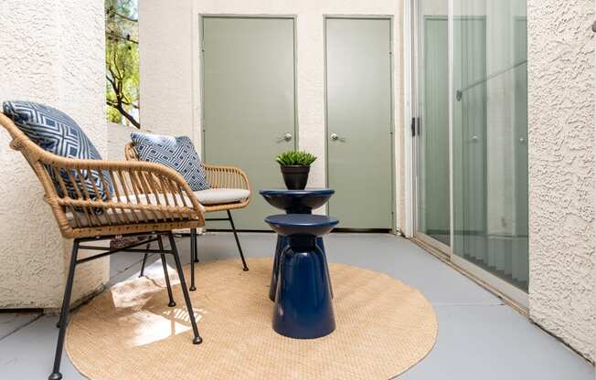 a patio with two chairs and a table and a door