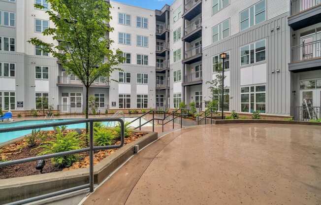 an empty courtyard with an apartment building and a pool